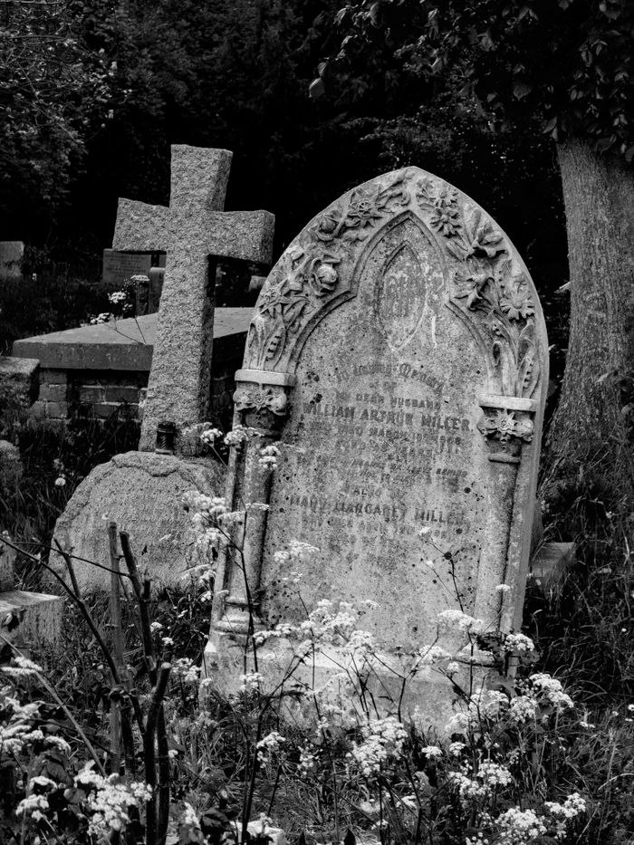 An evocative black and white image of gravestones in a historic church graveyard, evoking a sense of timelessness.